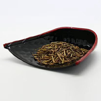 Roasted Japanese hojicha tea leaves in a black serving dish